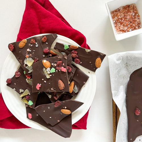 dark chocolate bark with sea salt and nuts and dried fruit on a plate