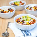 close up of burrito bowls topped with avocado