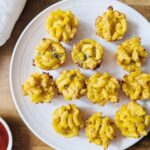close up of mac and cheese bites on a plate with a side of ketchup