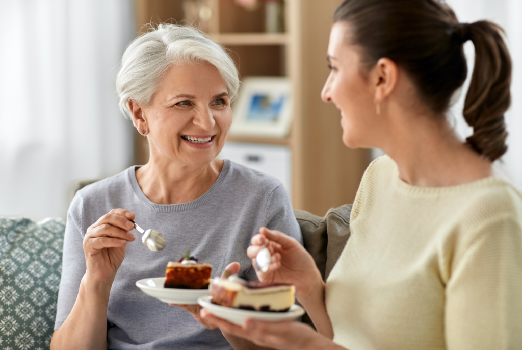 two women in perimenopause talking about a perimenopuase diet over a piece of cake