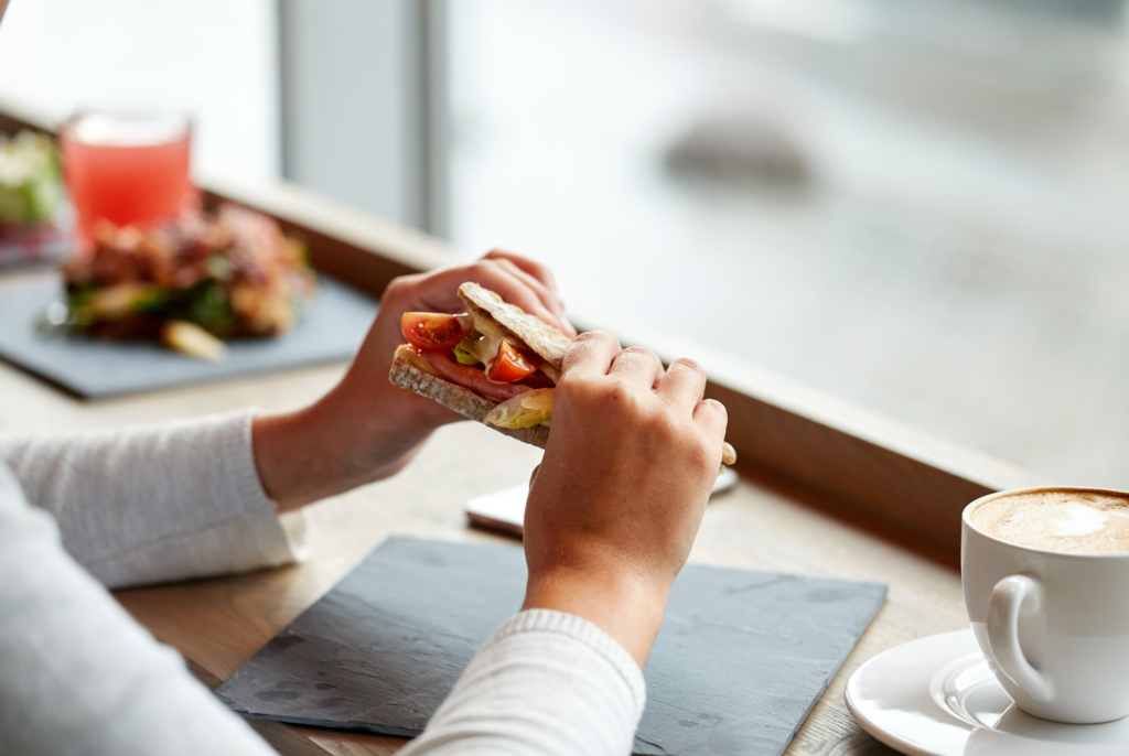 side view of a woman eating a salmon sandwich