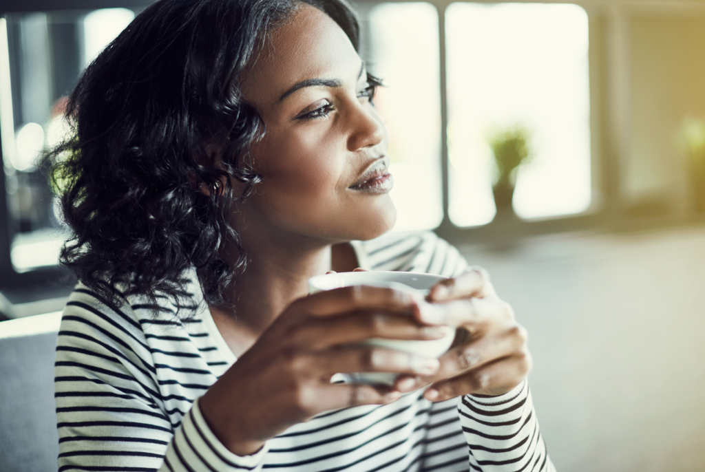 close up of a Black woman holding a cup of coffee