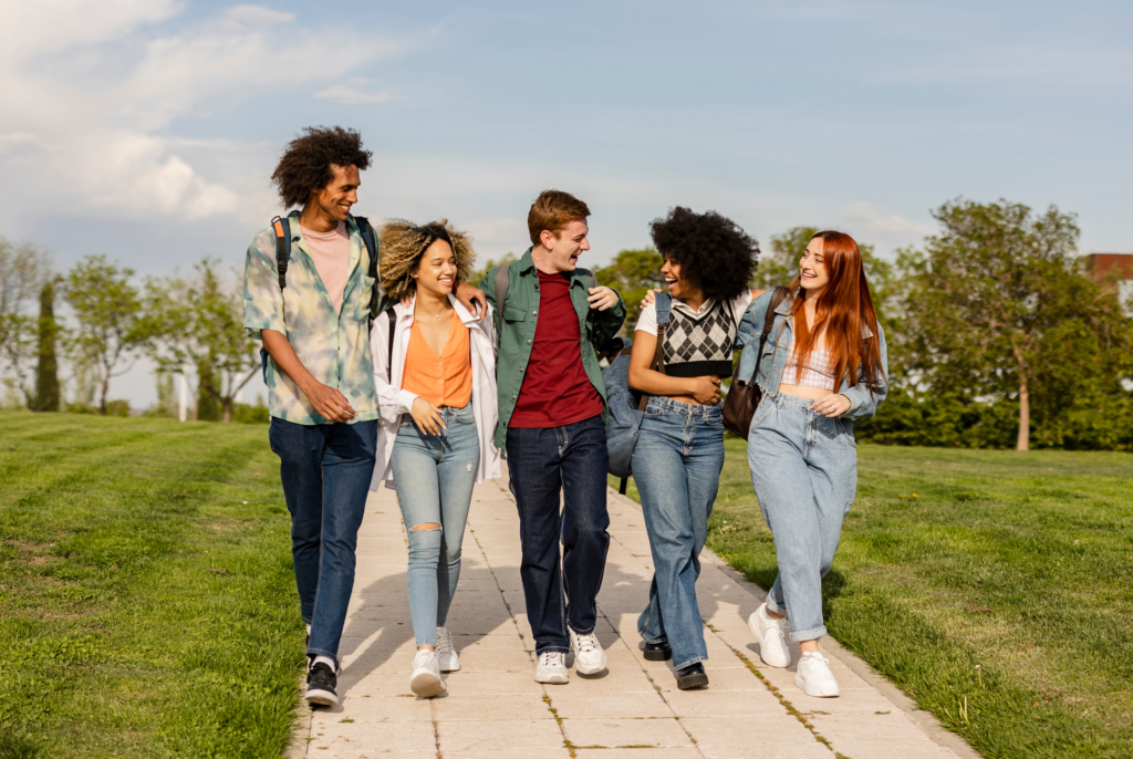 a bunch of active teens who just ate some healthy snacks, walking on a sidewalk and laughing together