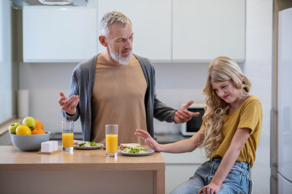 Dad trying to make his daughter eat lunch because teenager is a picky eater