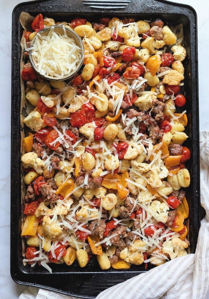 top down of sheet-pan gnocchi on a baking sheet with parmesan cheese