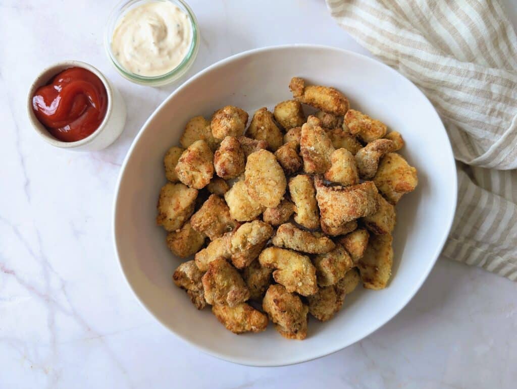 top down view of chicken nuggets in a big bowl with ketchup and mayo