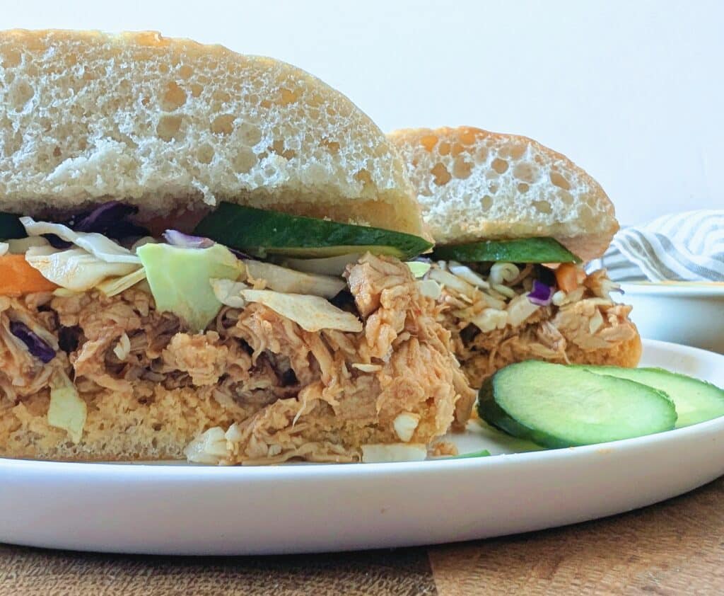 side view of a sliced ​​gochujang chicken sandwich on a plate