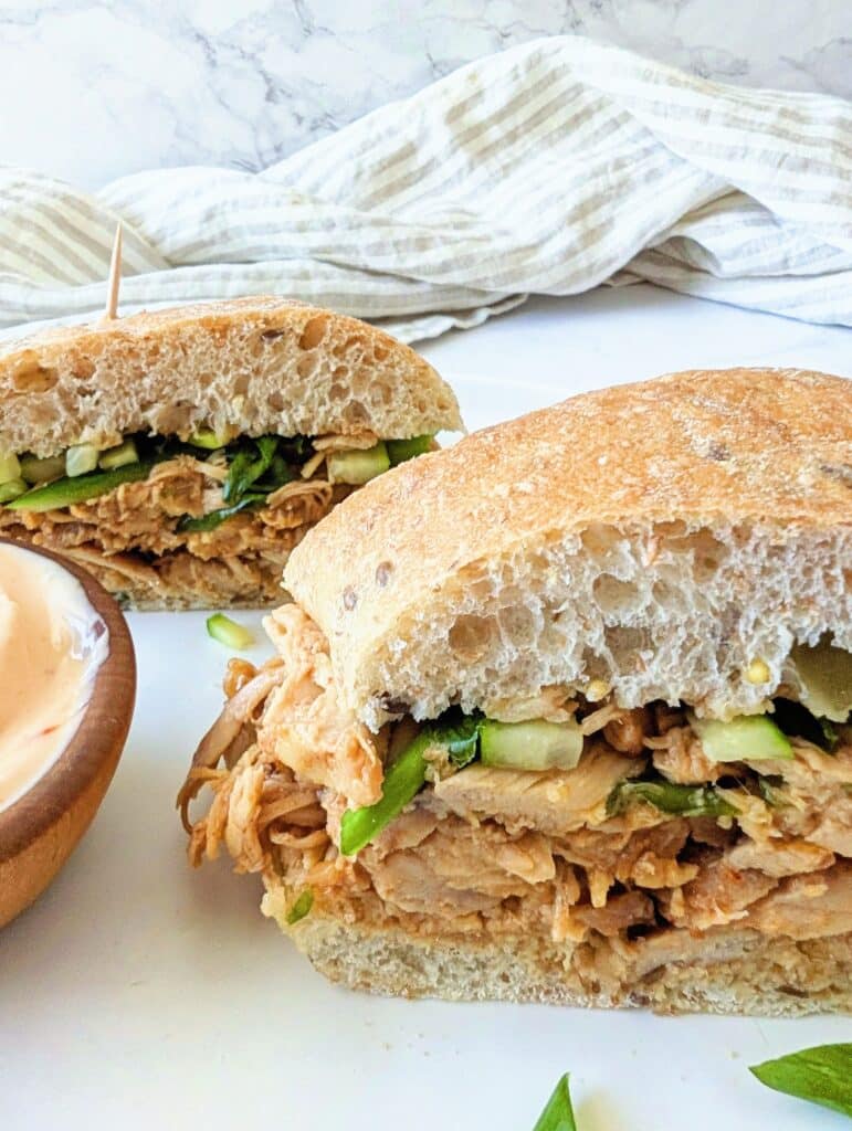 close-up of gochujang chicken sandwich on a plate with mayonnaise sauce on the side