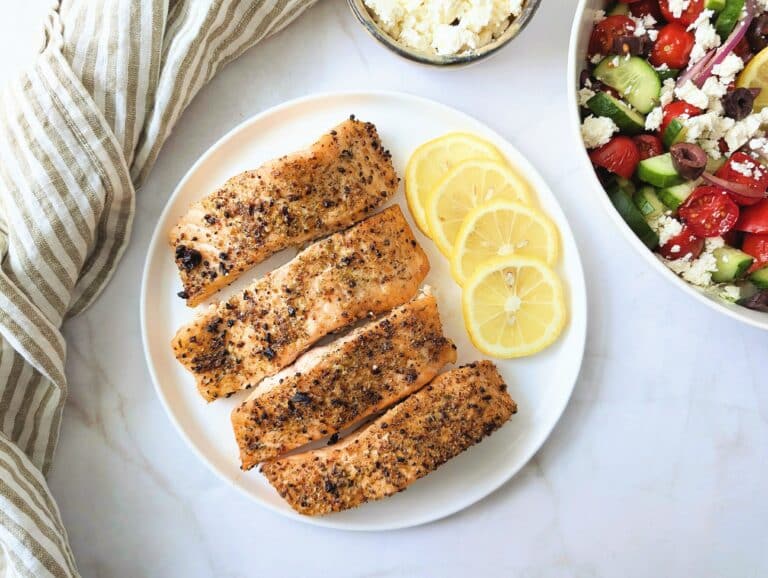 air fryer Greek salmon on a plate with a side of Greek salad