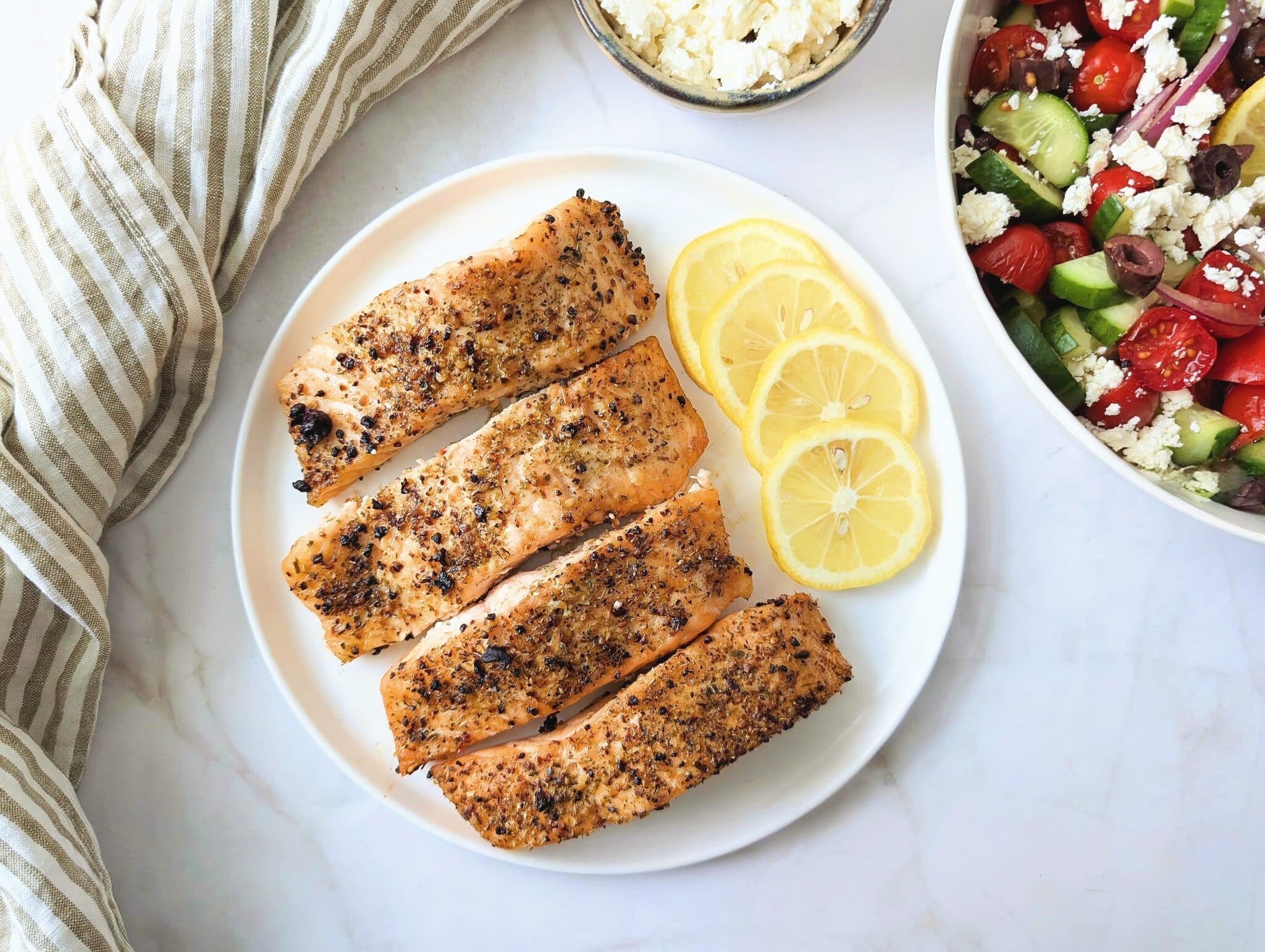 air fryer Greek salmon on a plate with a side of Greek salad