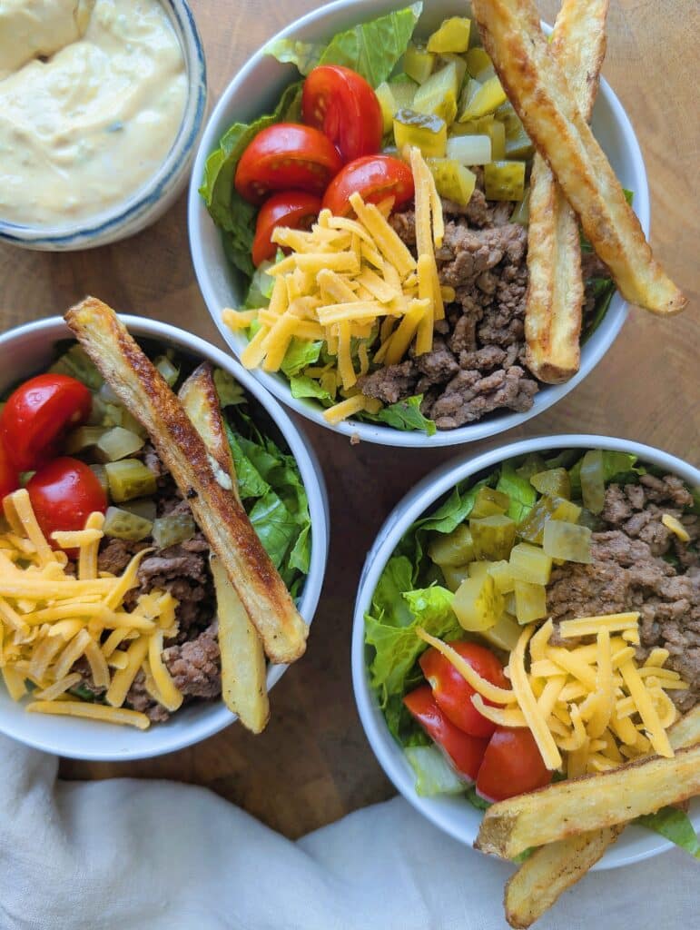 top down view of three cheeseburger bowls assembled