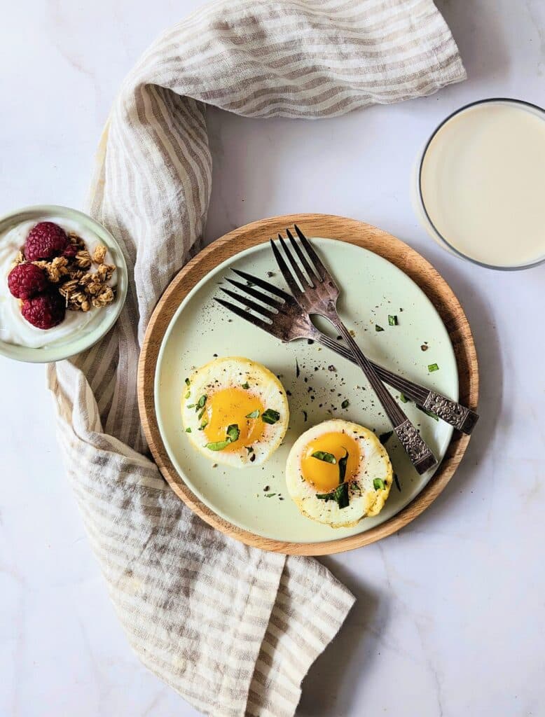 top view of egg cups with a side of yogurt and berries