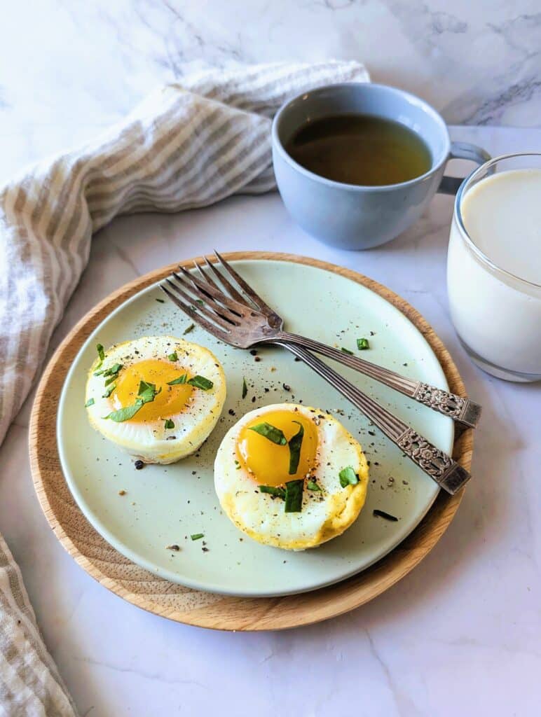 side view of cups of baked eggs with vegetable crust on a plate