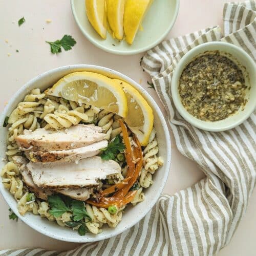 top down view of chicken pesto pasta in a white bowl