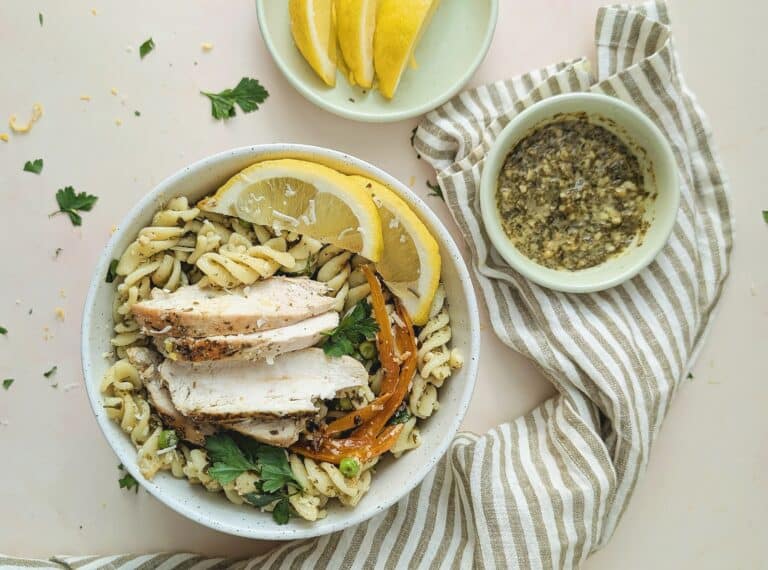 top down view of chicken pesto pasta in a white bowl
