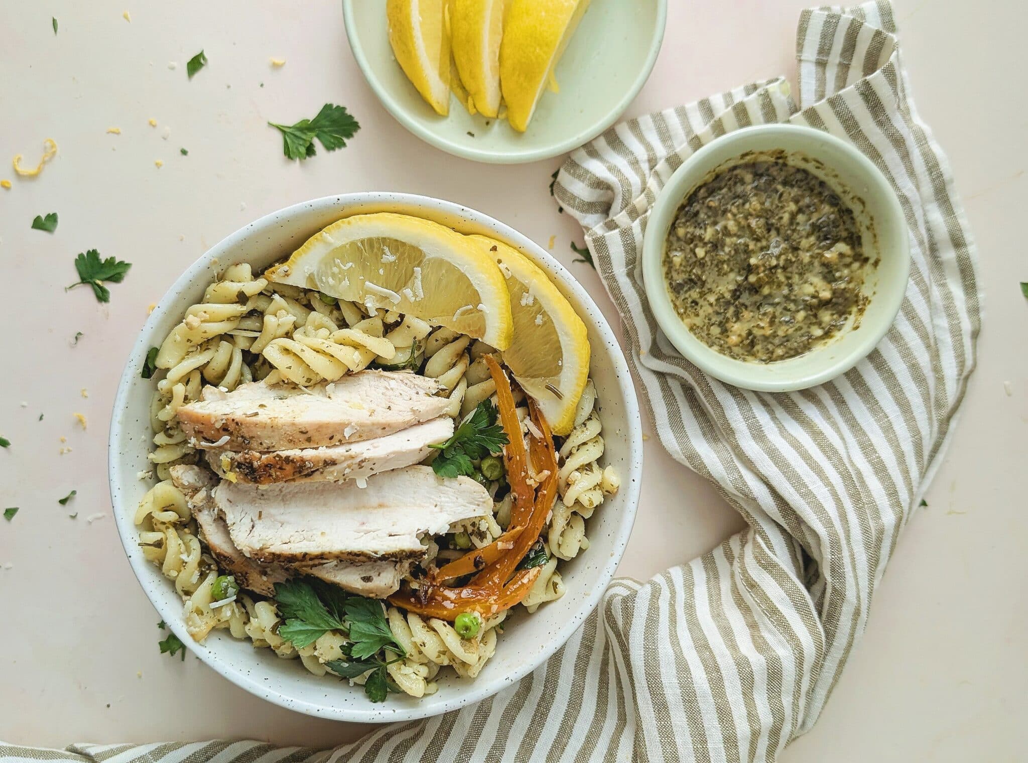 top down view of chicken pesto pasta in a white bowl