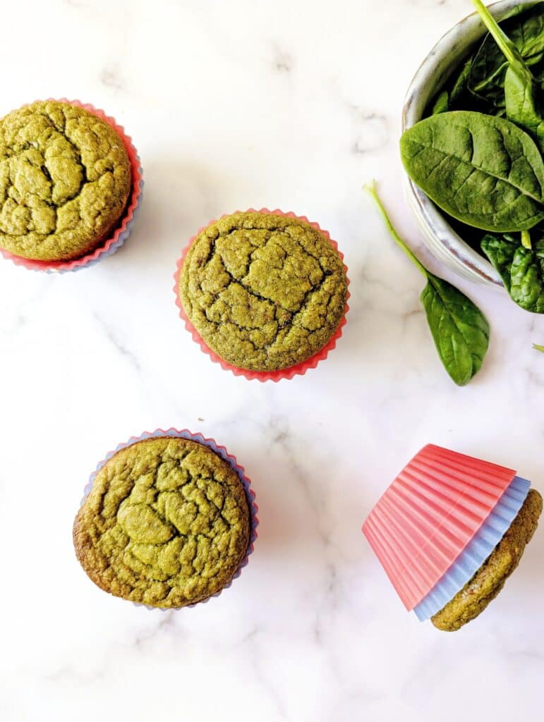 top down view of green spinach muffins on a marble surface