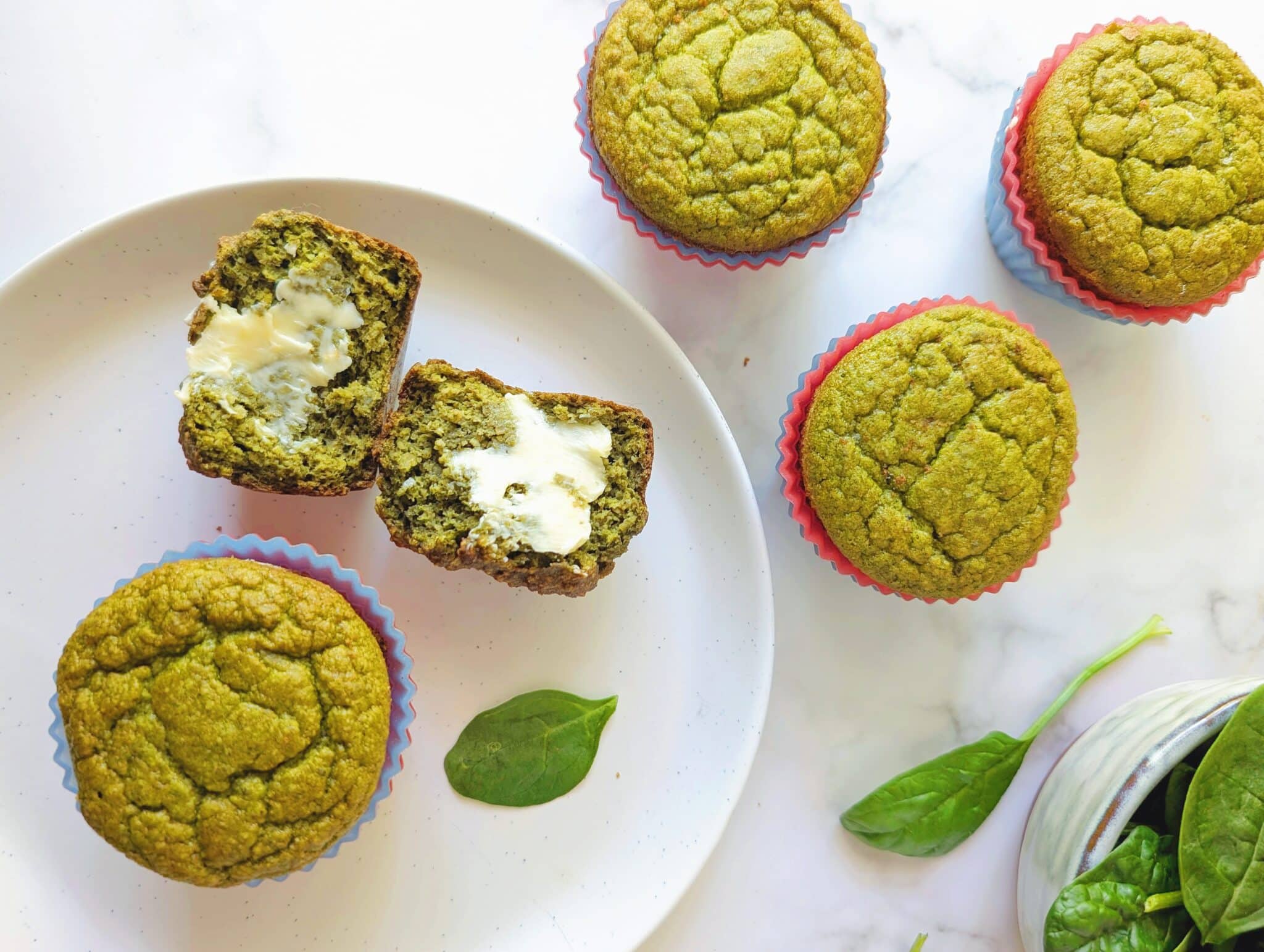 banana spinach blender muffins on a plate with butter