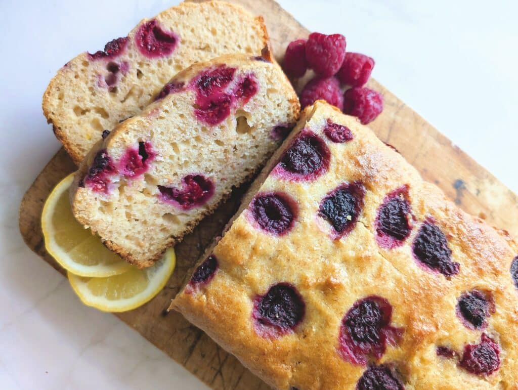 Top down view of raspberry lemon loaf cut into two slices on a cutting board