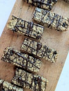top down view of chocolate drizzled granola bars on a board