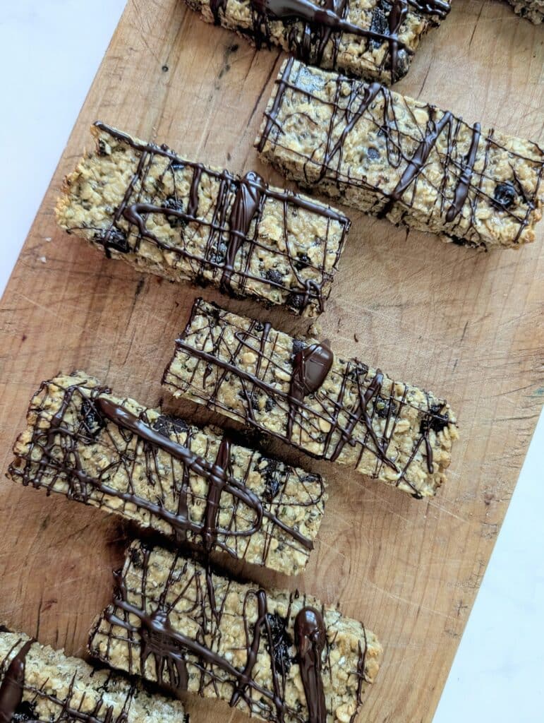 top down view of chocolate drizzled granola bars on a board