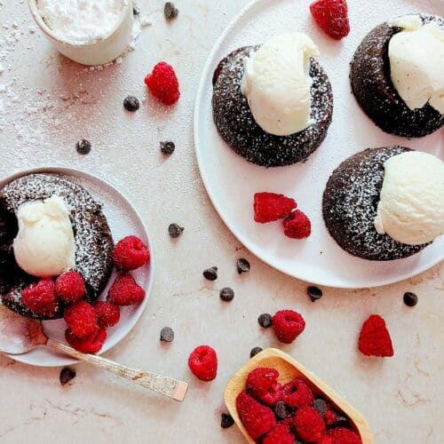 lava cakes with ice cream and raspberries on a plate top down view